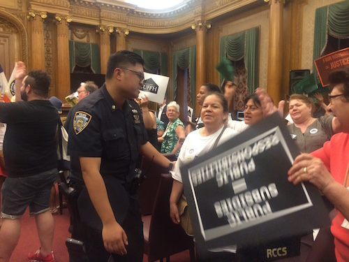 New York Police Officer attempting to escort protestors outside after the abrupt conclusion of the BP Adams ULURP meeting