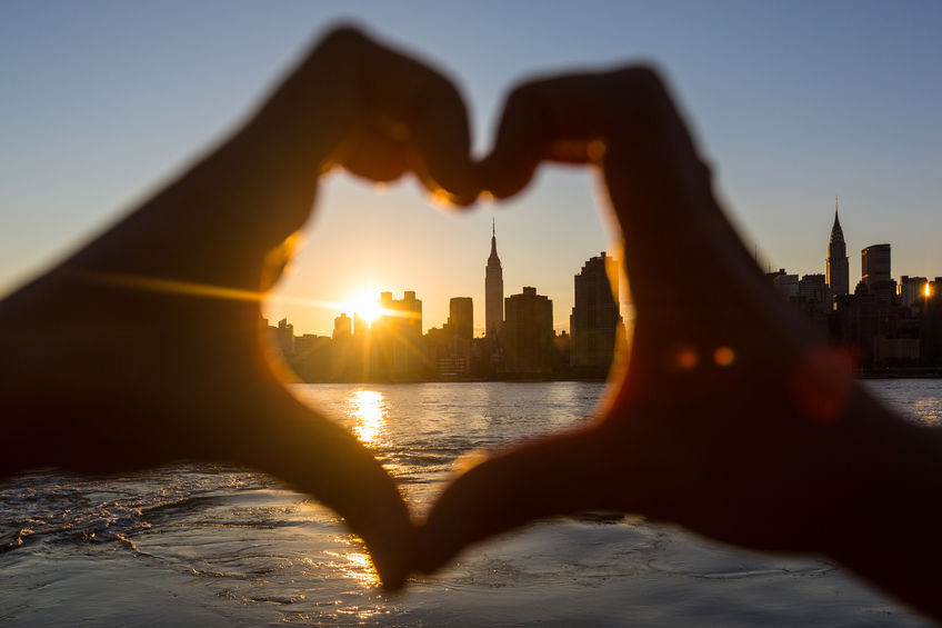 Heart Shaped Hands at Sunset, New York Skyline on Background
