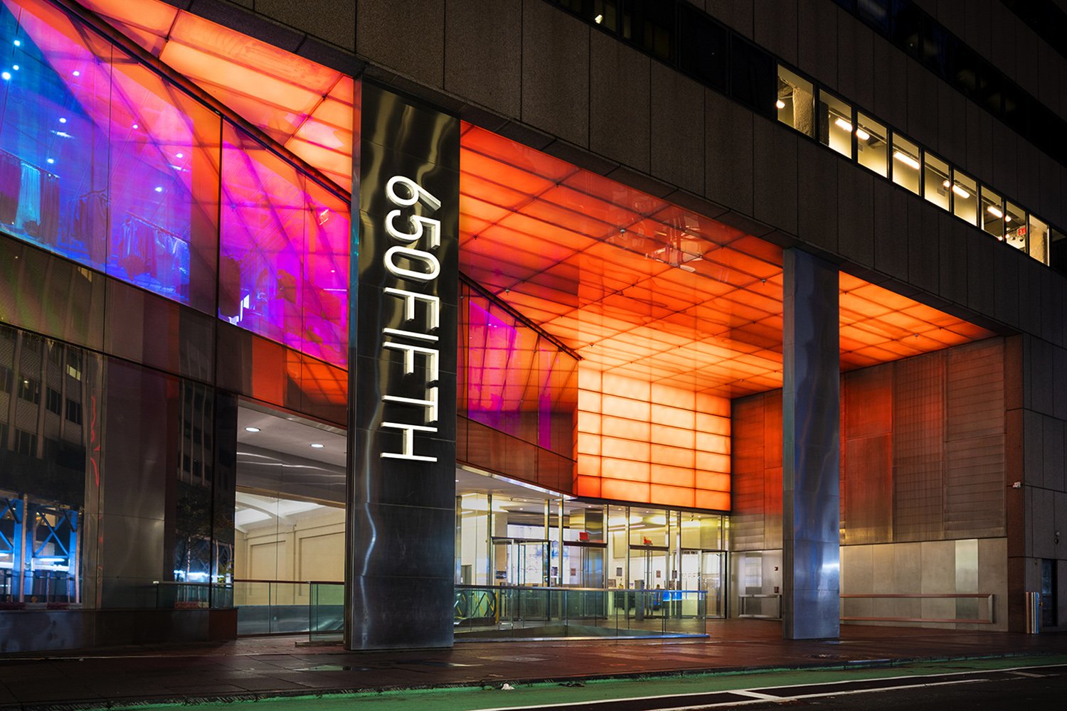 650 Fifth Avenue entrance at night with colorful lighting