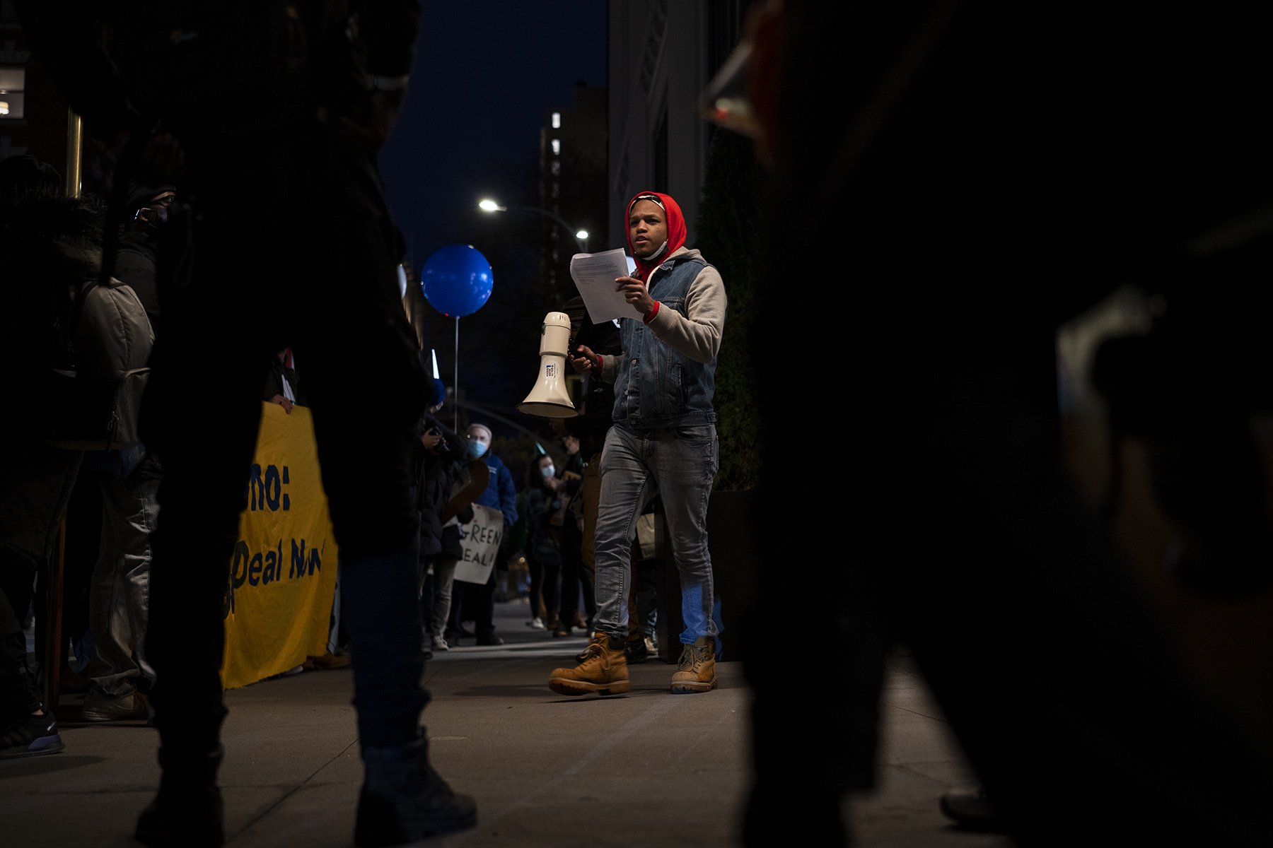 Sunrise NYC member Drake Hunt with a megaphone in front of a crowd of protesters (Photo credit: Tsubasa Berg)
