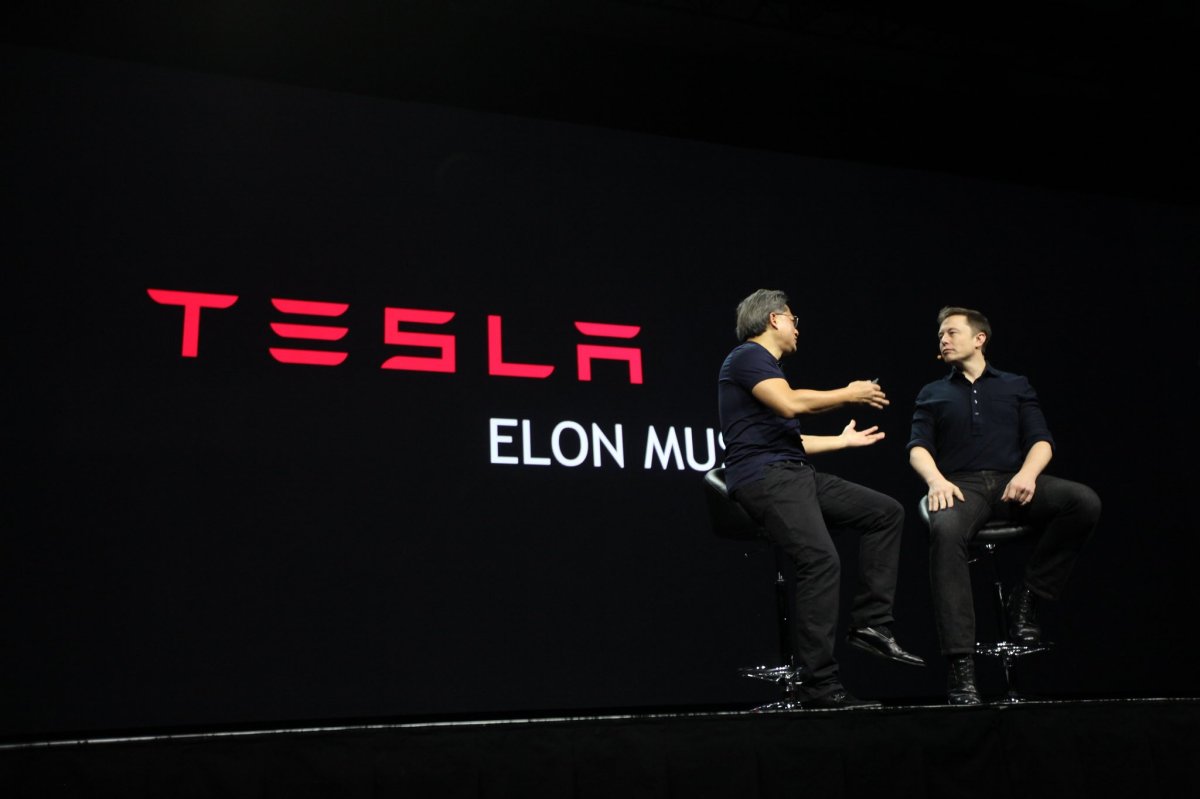 Elon Musk on stage with NVIDIA CEO and co-founder Jen-Hsun Huang with text "Tesla, Elon Musk" on the back