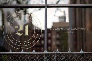 21 in '21 emblem and text that reads "Ladies - we want you!, 21in21.org" on window