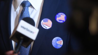 "I voted" "future Voter" "I voted!" badges on a man in a suit