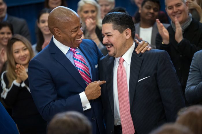 Brooklyn Borough President Eric Adams with Schools Chancellor Richard A. Carranza surrounded by adults clapping hands.