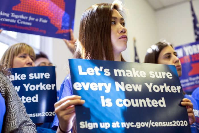 A group of women holding signs that read "Let's make sure every New Yorker is counted, sign up at nyc.gov/census2020" at Press Conference Highlighting the Importance and Funding Needs of the Upcoming Census