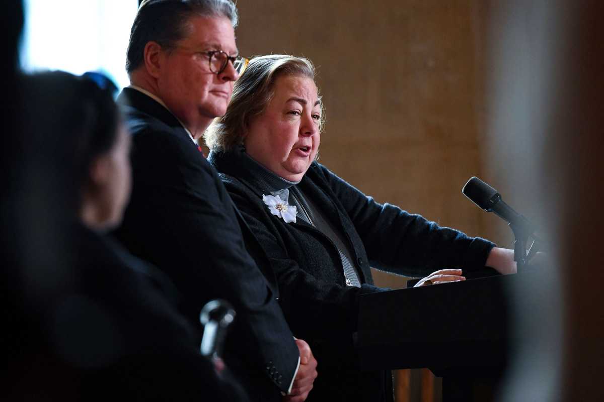 State Senator Liz Krueger standing next to Senator Harckham speaking on microphone