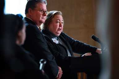 State Senator Liz Krueger standing next to Senator Harckham speaking on microphone