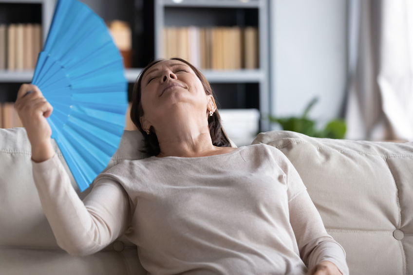 Overheated senior woman relax using hand fan