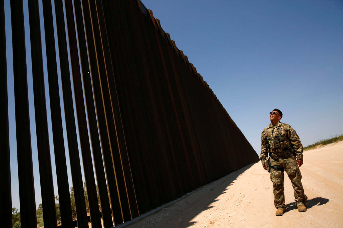 A member of BORSTAR observes the border wall in New Mexico
