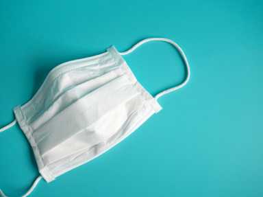 close up white surgical face mask on blue green background , the equipment mask to protect man health from flu , coronavirus infection , Health care concept
